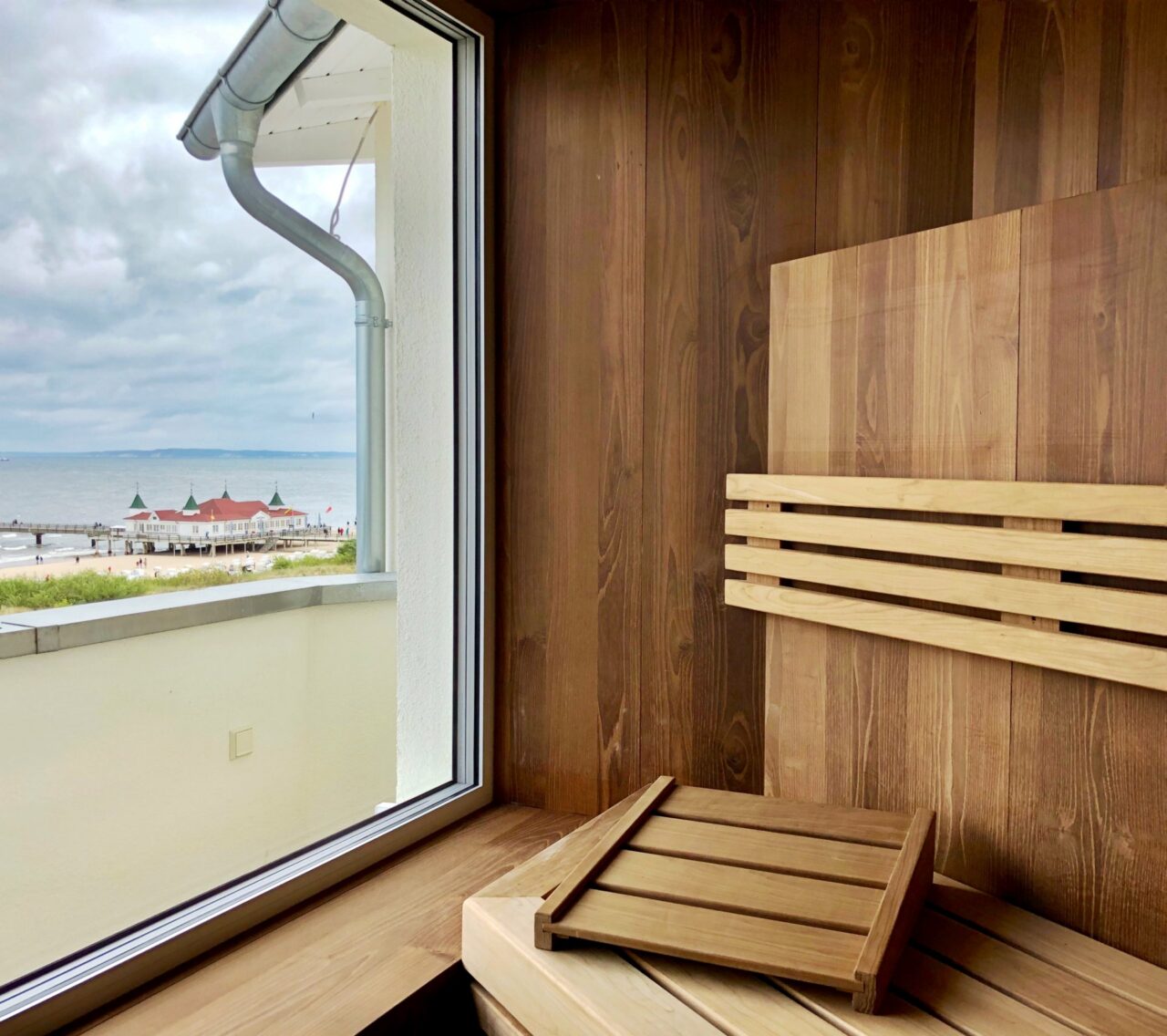 Panorama-Sauna im Das Ahlbeck Hotel & Spa mit Blick auf die Ostsee und die Seebrücke Ahlbeck durch das Fenster